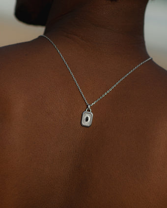 Layered necklace with white pearls and turquoise beads on a silver chain around the neck.