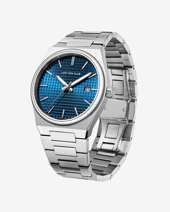 Close up of AUREN watch with a blue grid dial and brushed stainless steel case and bracelet