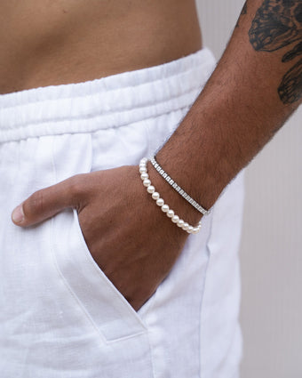 Close-up of a 4 mm icy tennis bracelet on a tattooed wrist.