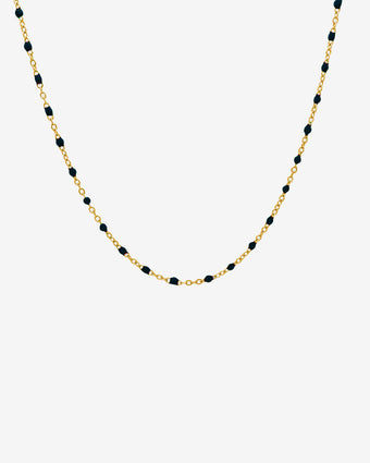 Gold chain necklace with evenly spaced black beads, 50 cm long, on a white background.