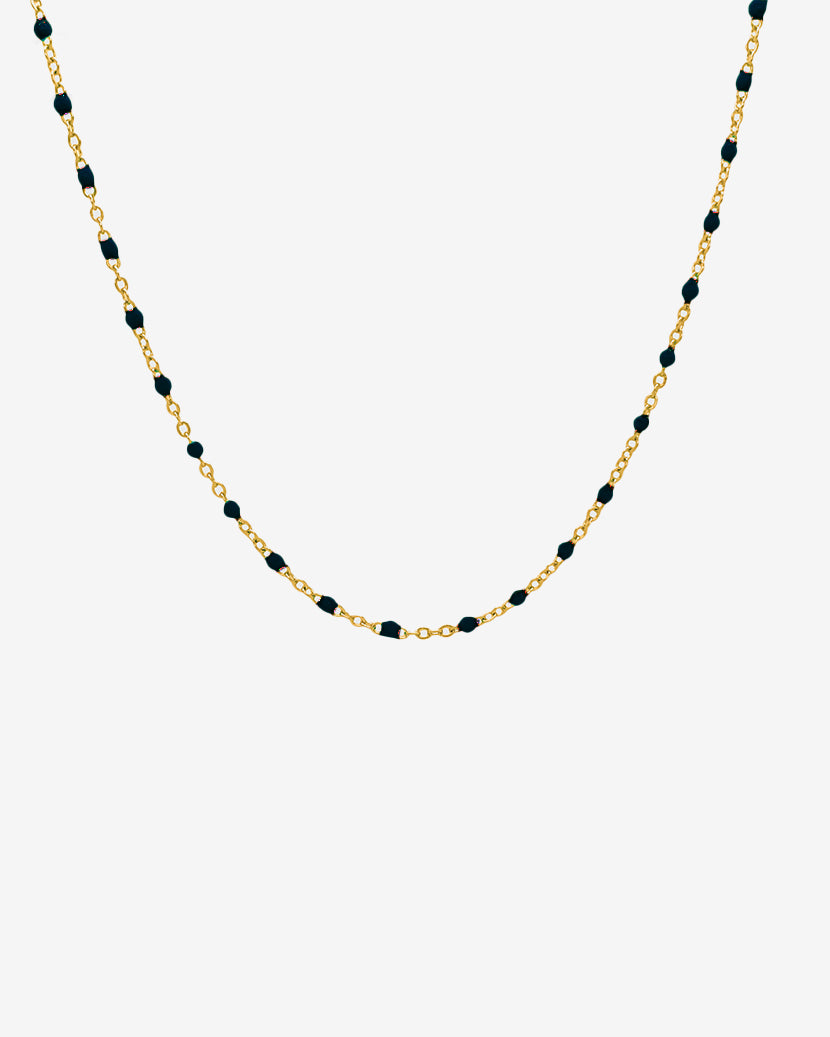 Gold chain necklace with evenly spaced black beads, 50 cm long, on a white background.
