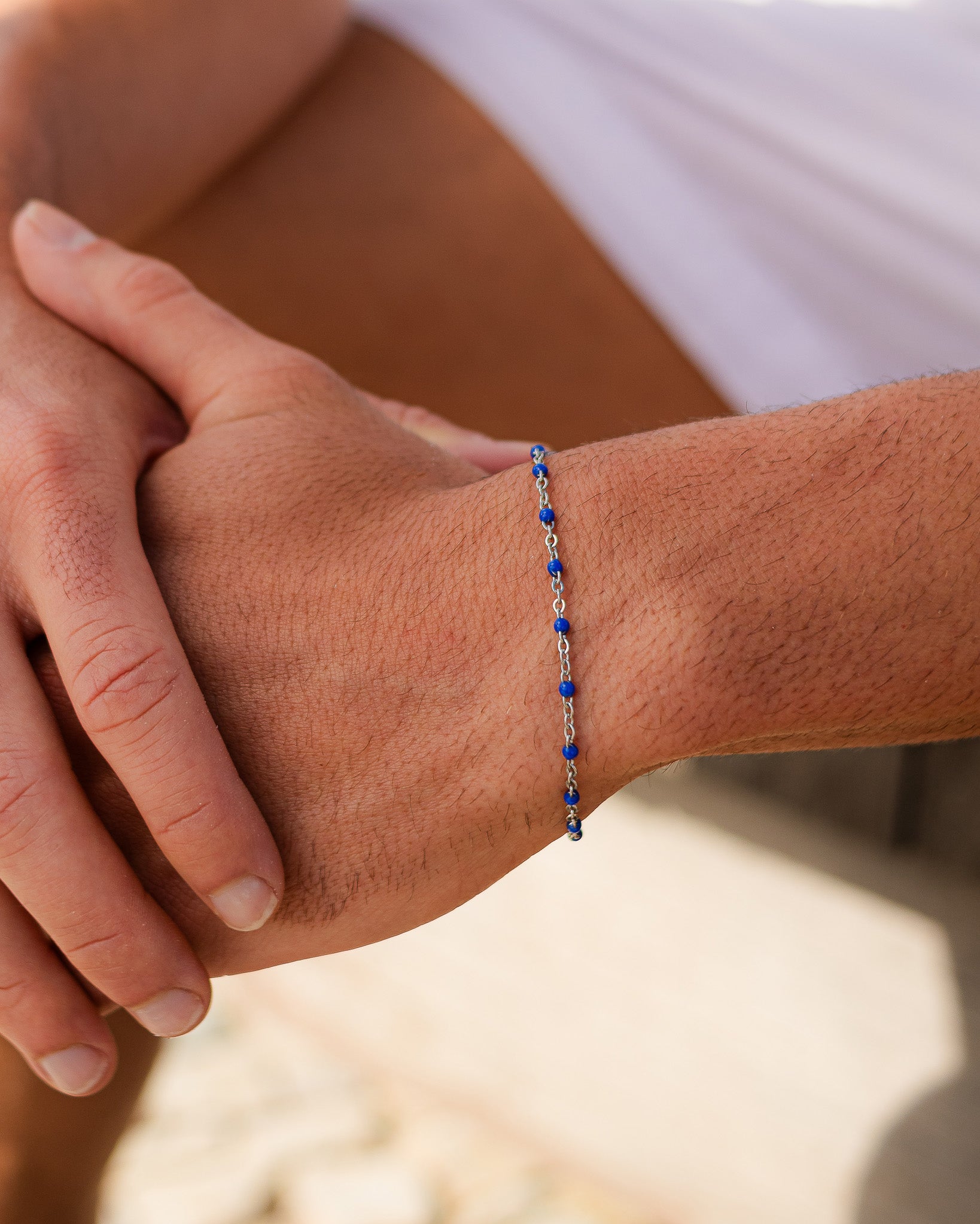 Silver bracelet with blue beads worn on the wrist