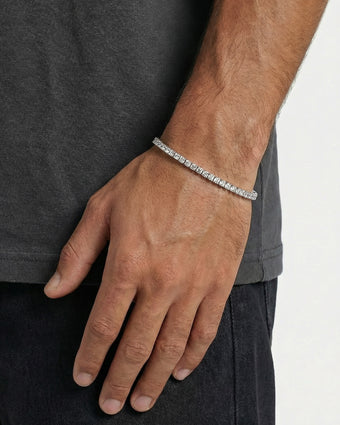 Person wearing a 4 mm icy tennis bracelet on the wrist, paired with a pearl bracelet.