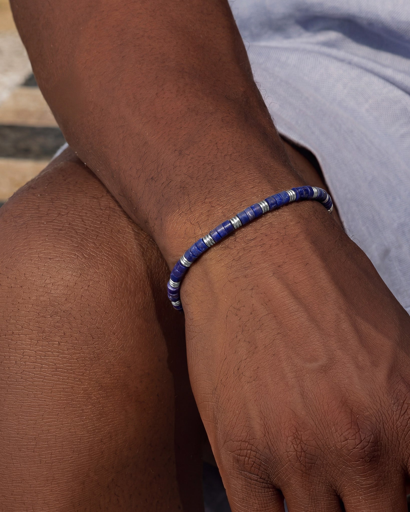Blue lapis bead bracelet with silver spacer beads on the wrist.