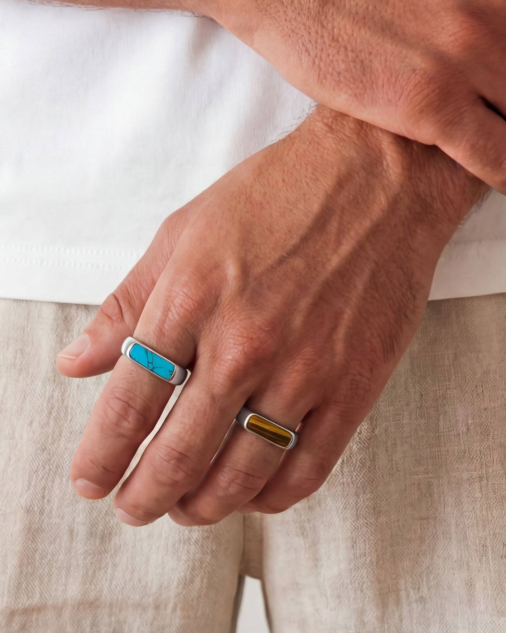 Hand wearing NOVA SILVER RING with turquoise inlay on the finger against a light background