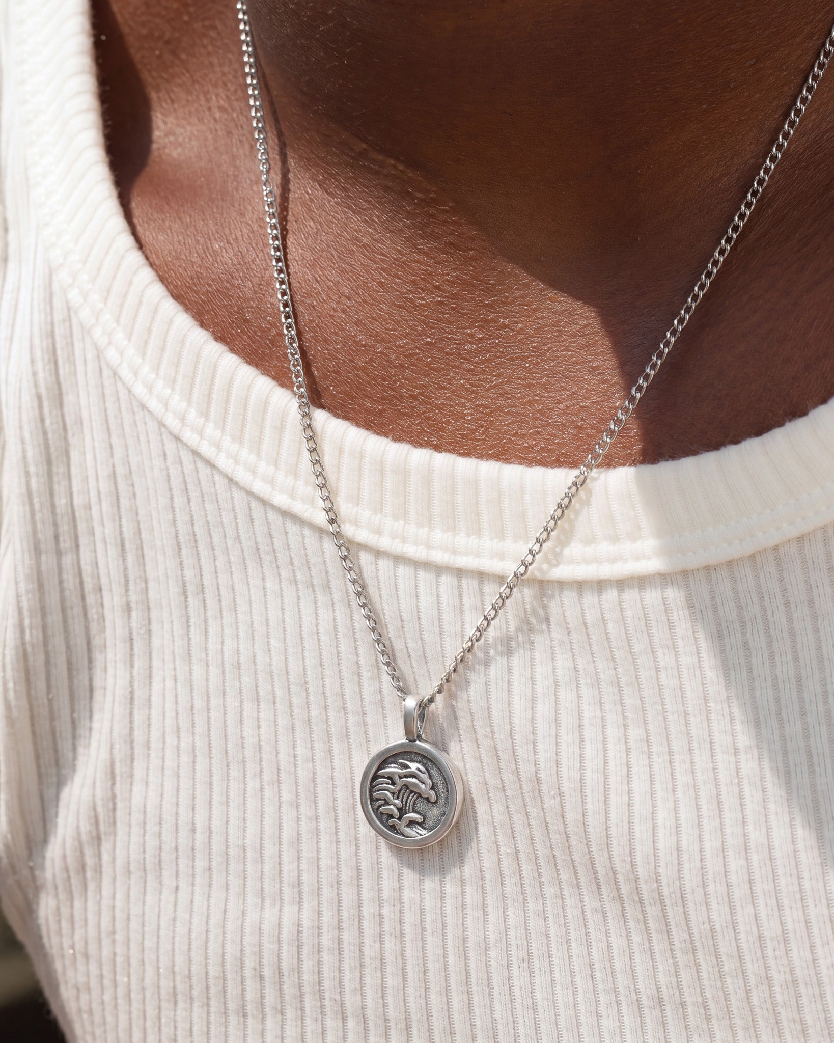 Oahu silver necklace featuring a round pendant with a wave design