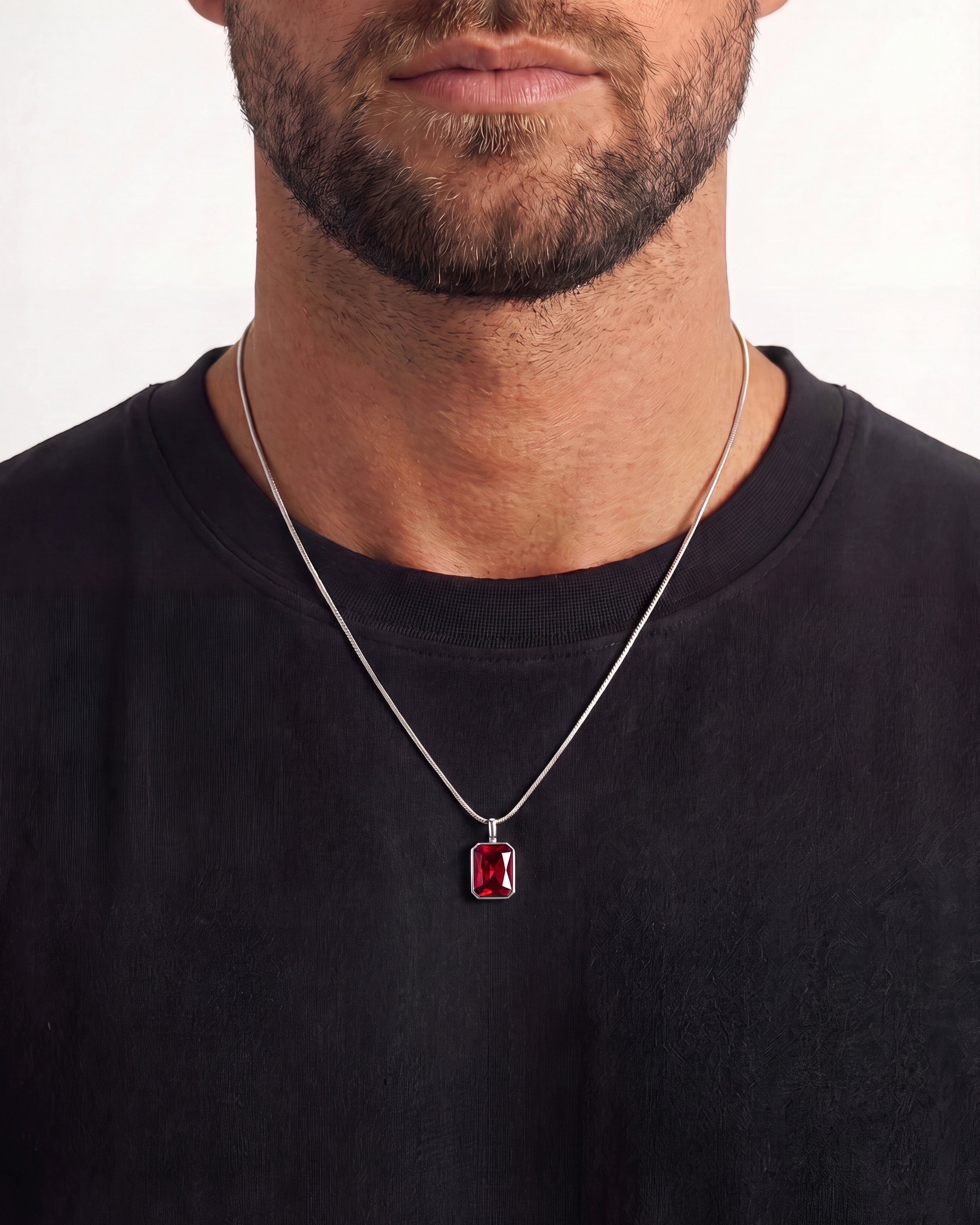 Collar plateado Solstice mostrando colgante rectangular de gema roja en bisel plateado sobre fondo blanco