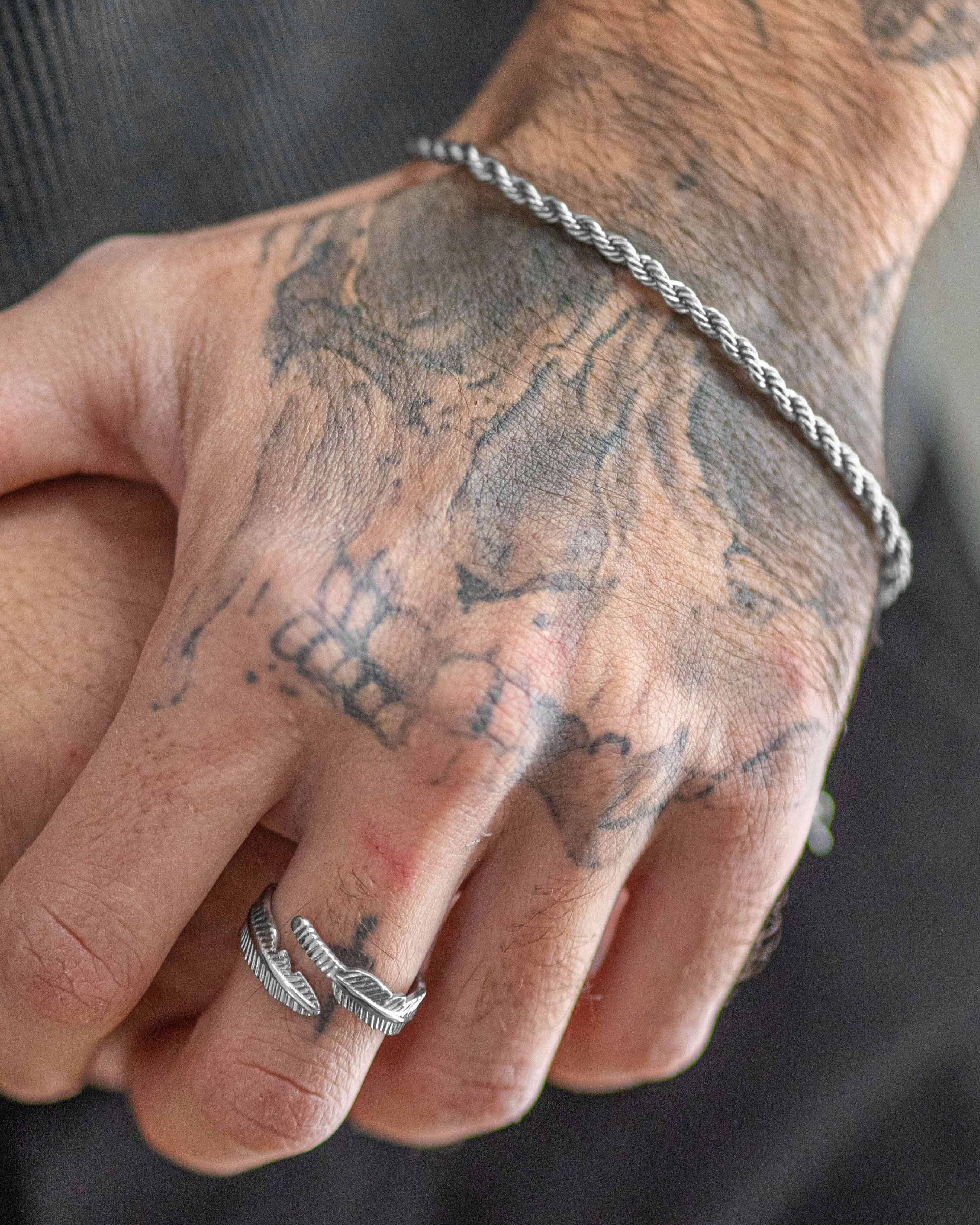 Minimalist Tahoe Silver Ring worn on a finger with visible tattoos on the hand