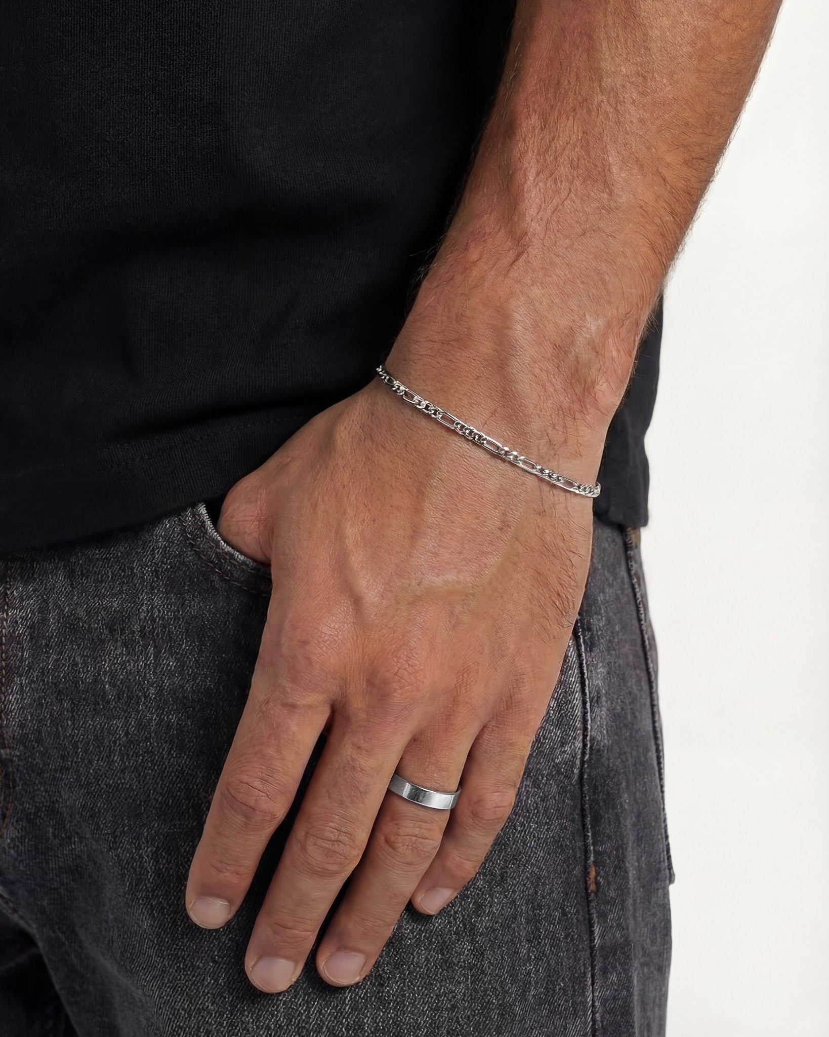 Side view of a hand wearing the VERO silver ring on the ring finger with a silver chain bracelet at the wrist