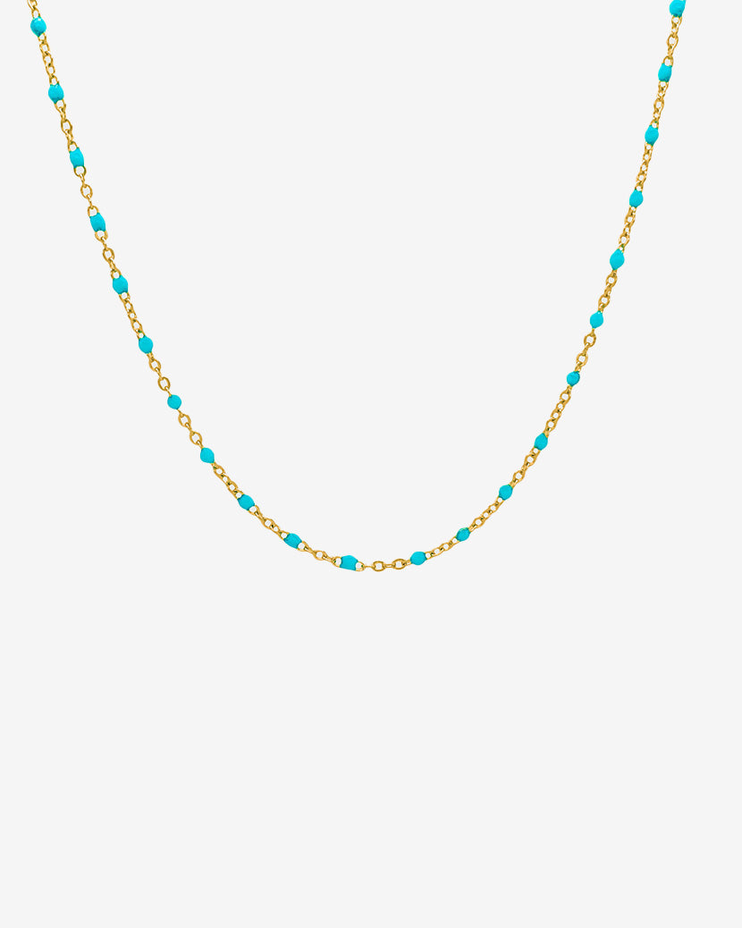 Gold chain necklace with turquoise beads displayed on a white background