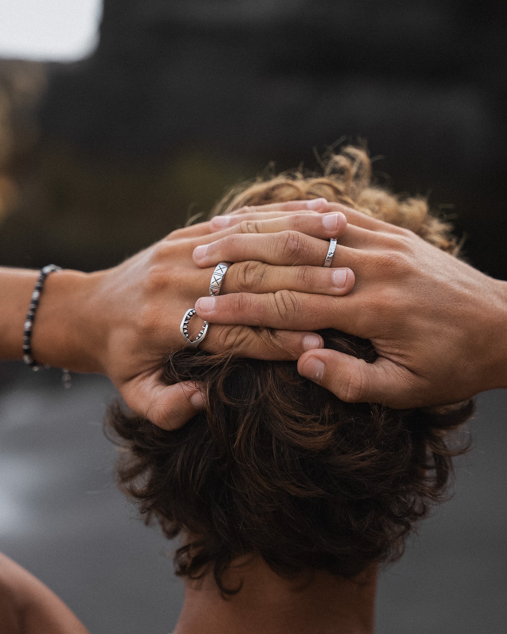 Dusky silver minimalist band worn on finger with hands clasped