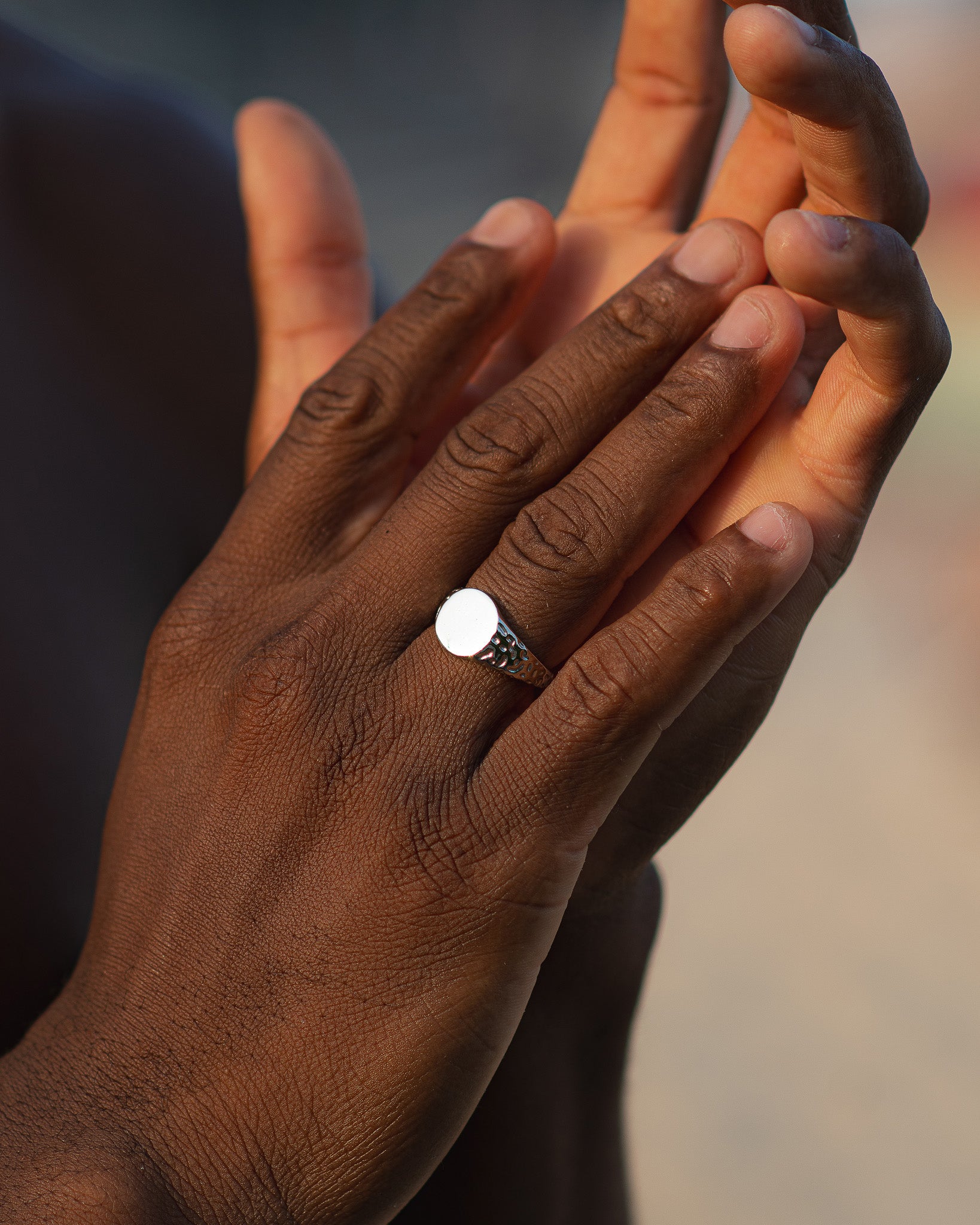Silver Eden Ring on the ring finger of a dark-skinned hand with a white shirt sleeve visible.