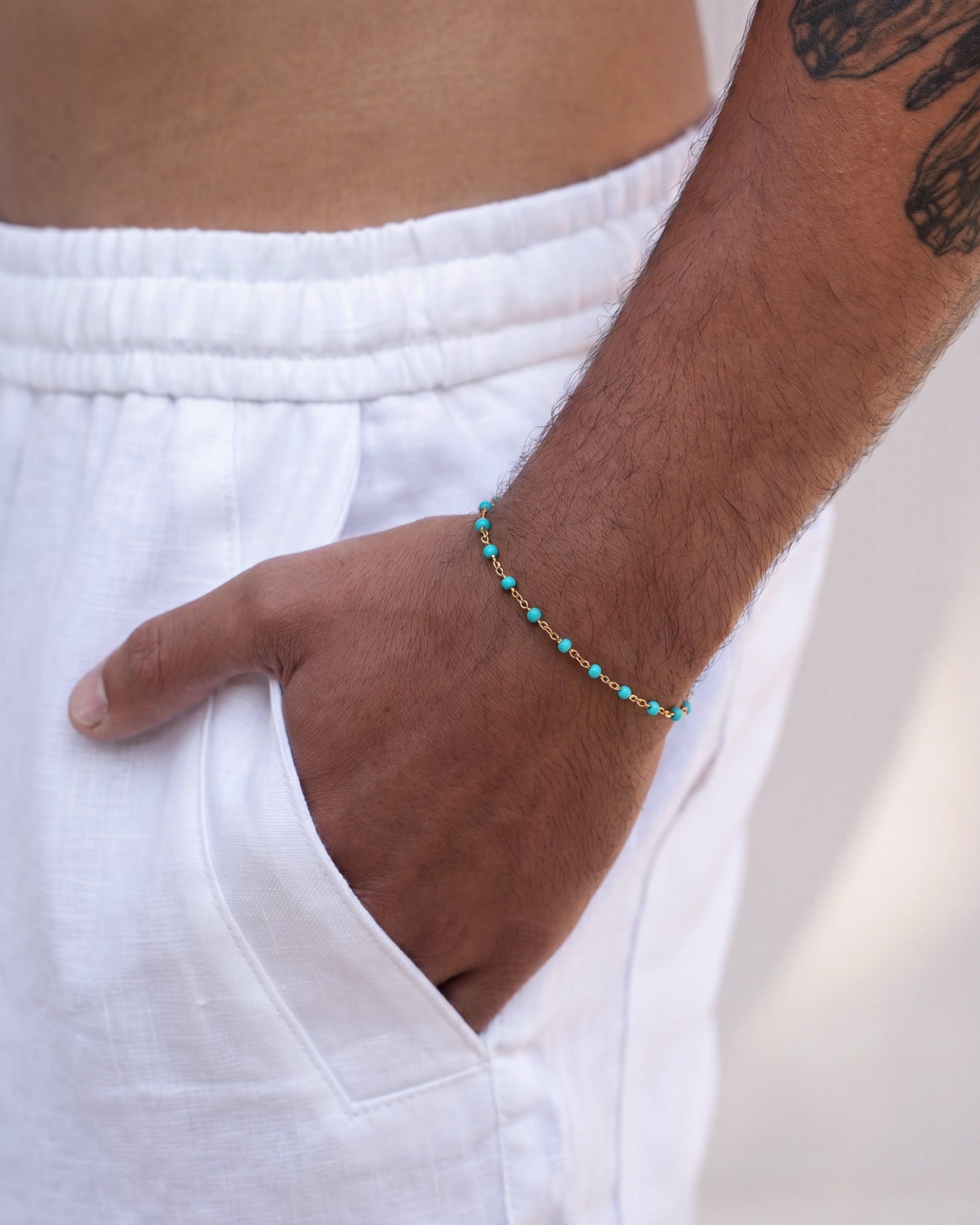 GEM GOLD BRACELET with turquoise beads on a gold chain around the wrist
