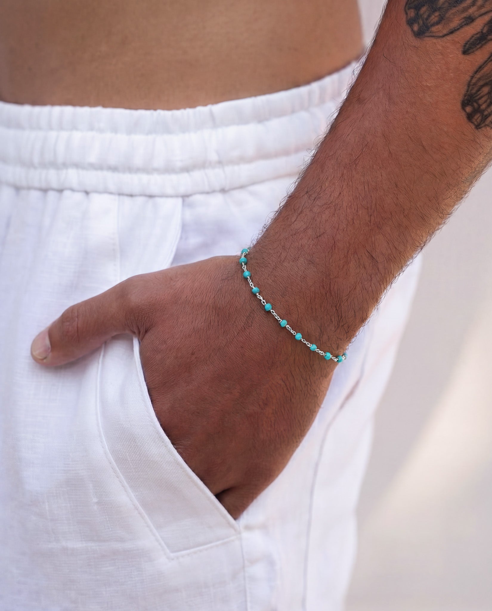 Silver bracelet with turquoise beads arranged along a delicate chain on a wrist