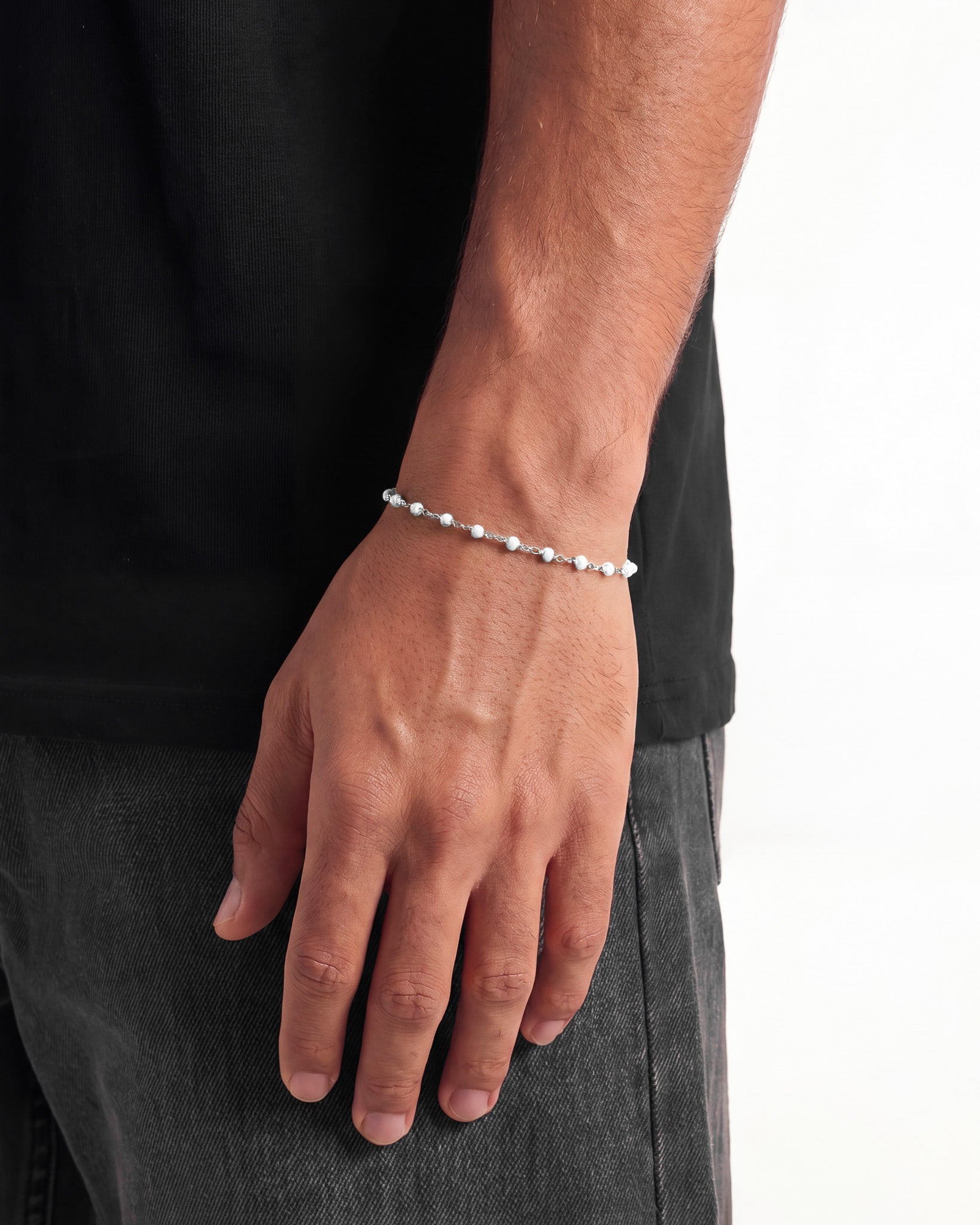 Model wears a silver beaded bracelet on the wrist