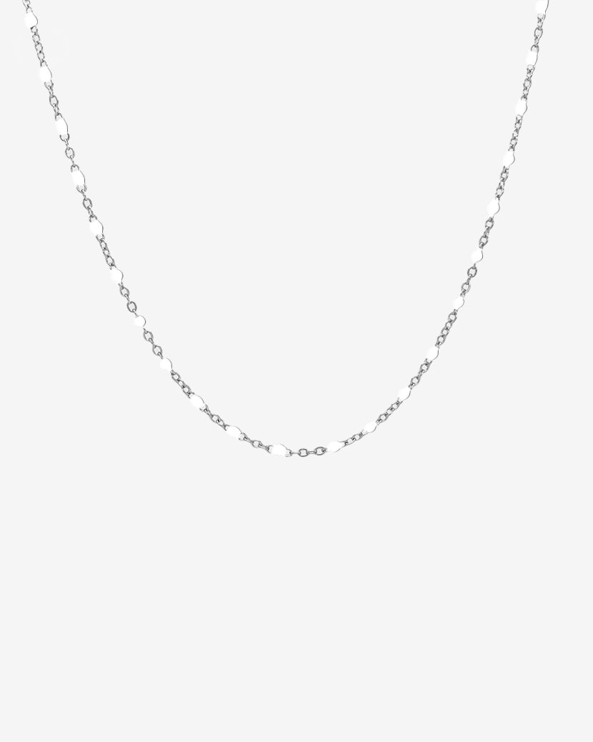 Delicate silver chain necklace with small white beads evenly spaced along the links