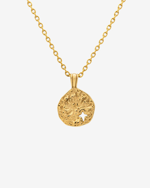 Primer plano del MIST GOLD NECKLACE con colgante redondo texturizado y recorte de estrella en cadena de 50 cm