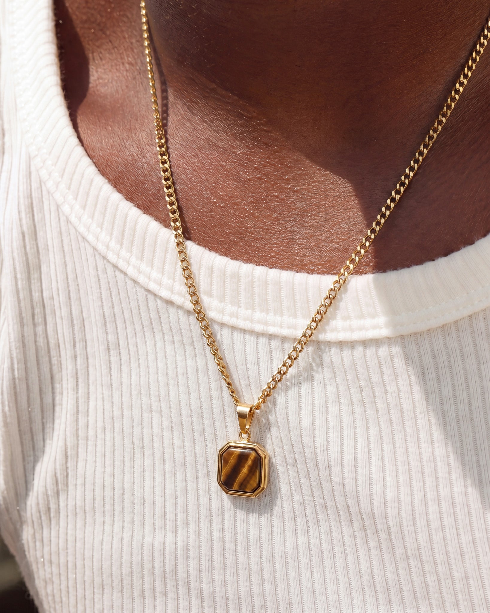Nova Gold Necklace with turquoise octagonal pendant worn over a white ribbed top.