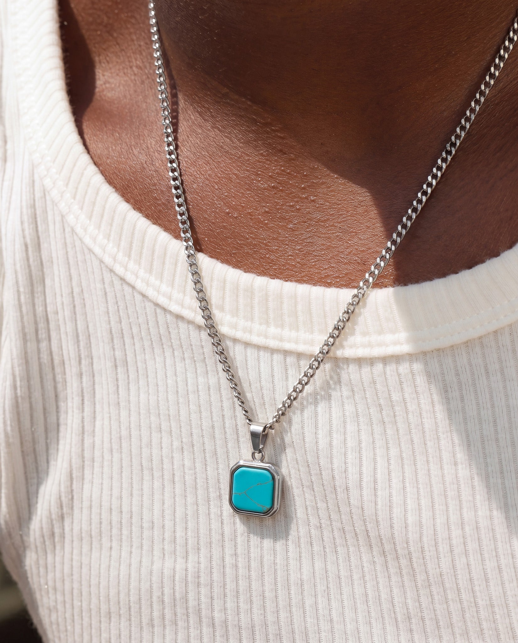 NOVA Silver Necklace with turquoise octagonal pendant resting on a model wearing a white ribbed sweater