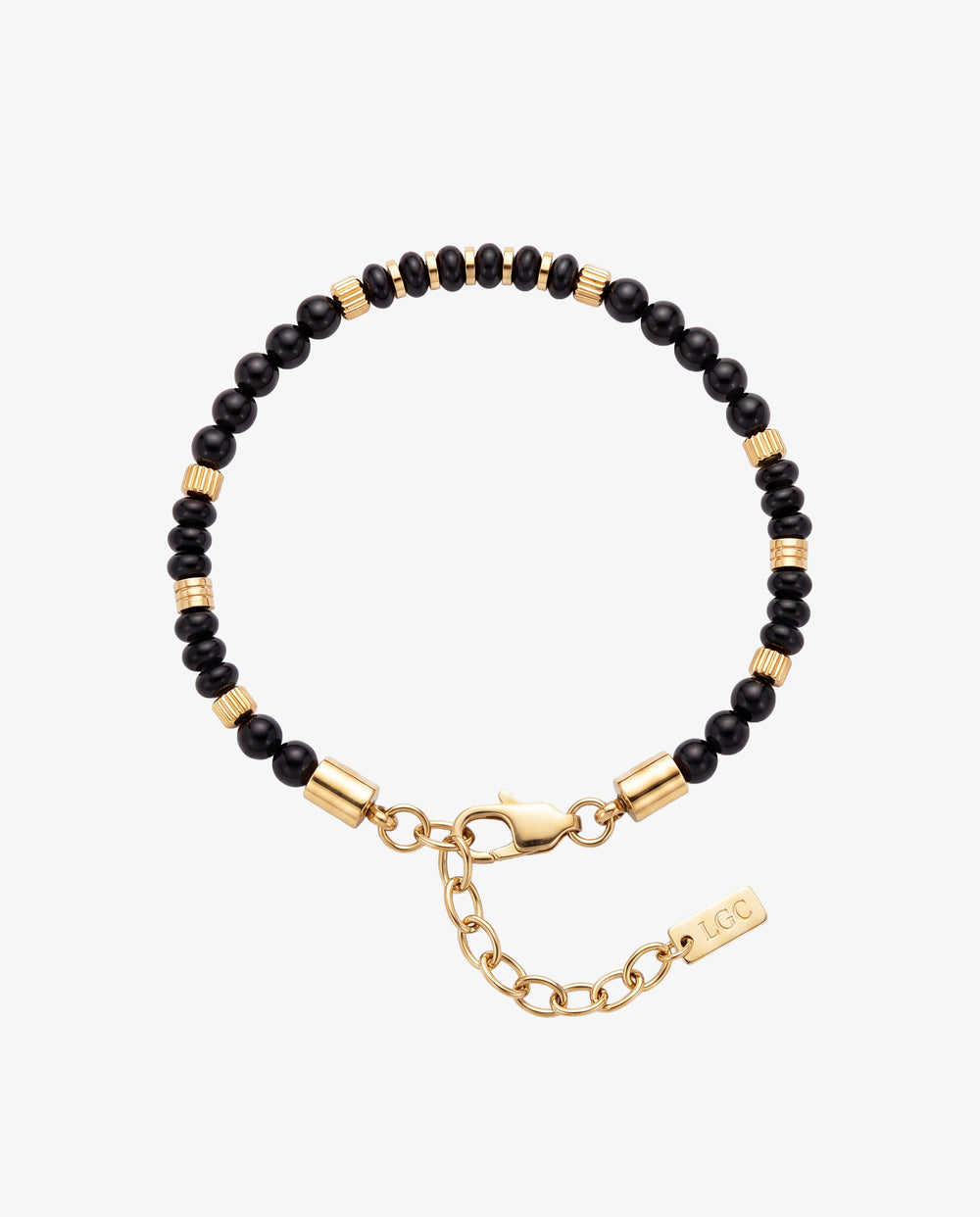 Black agate bead bracelet with gold cylindrical spacers around the wrist