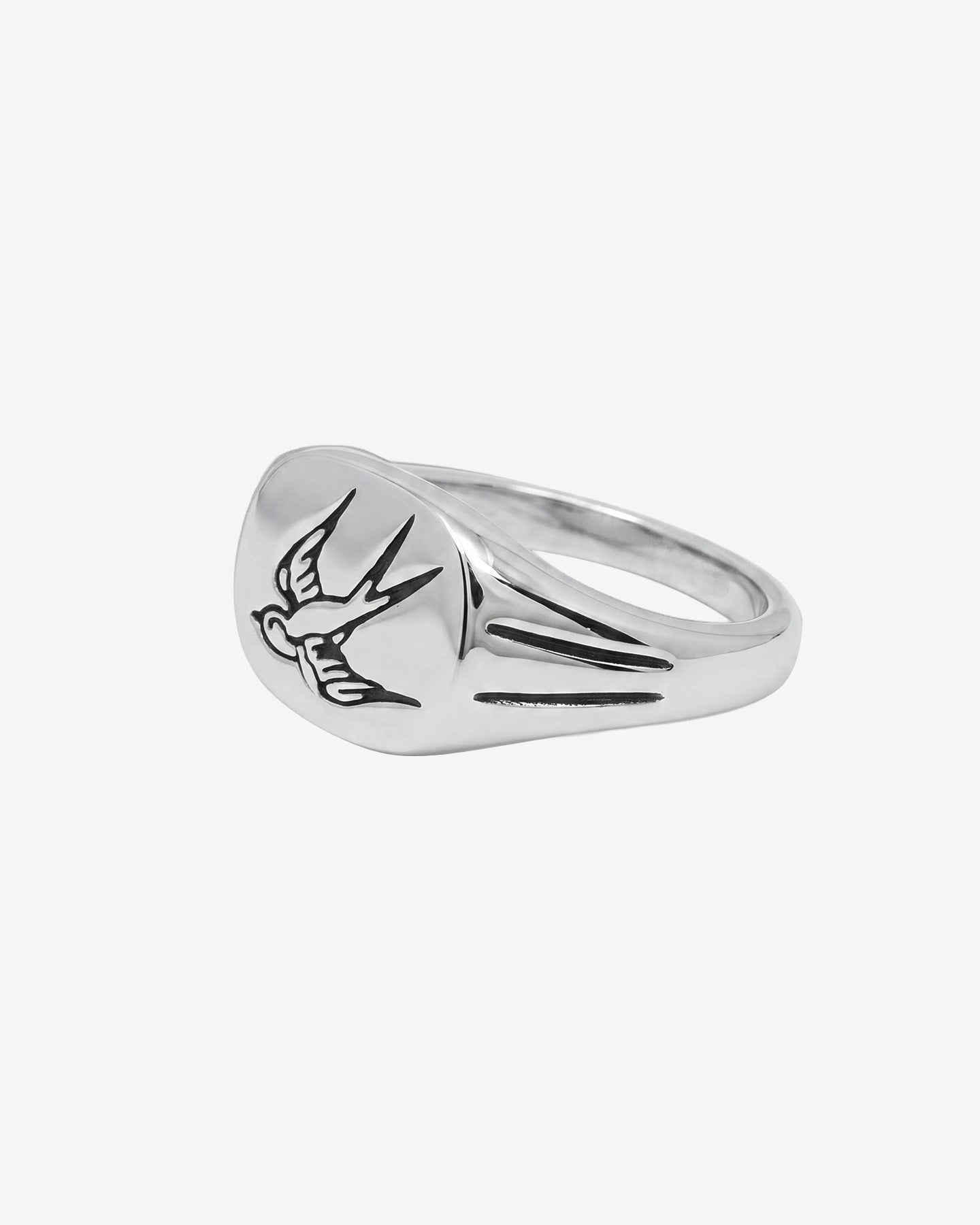 Anillo de plata con una golondrina en vuelo grabada en la parte superior redondeada