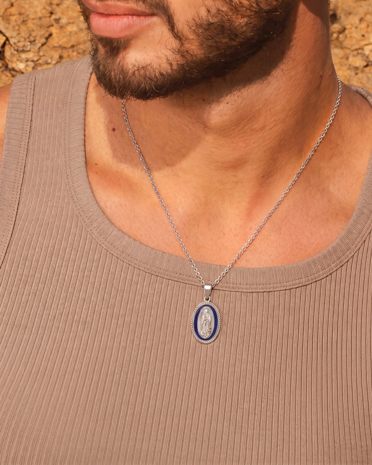 Mann mit einer silbernen Madonnen-Anhängerkette mit ovalem Medaillon in blauer Emaille