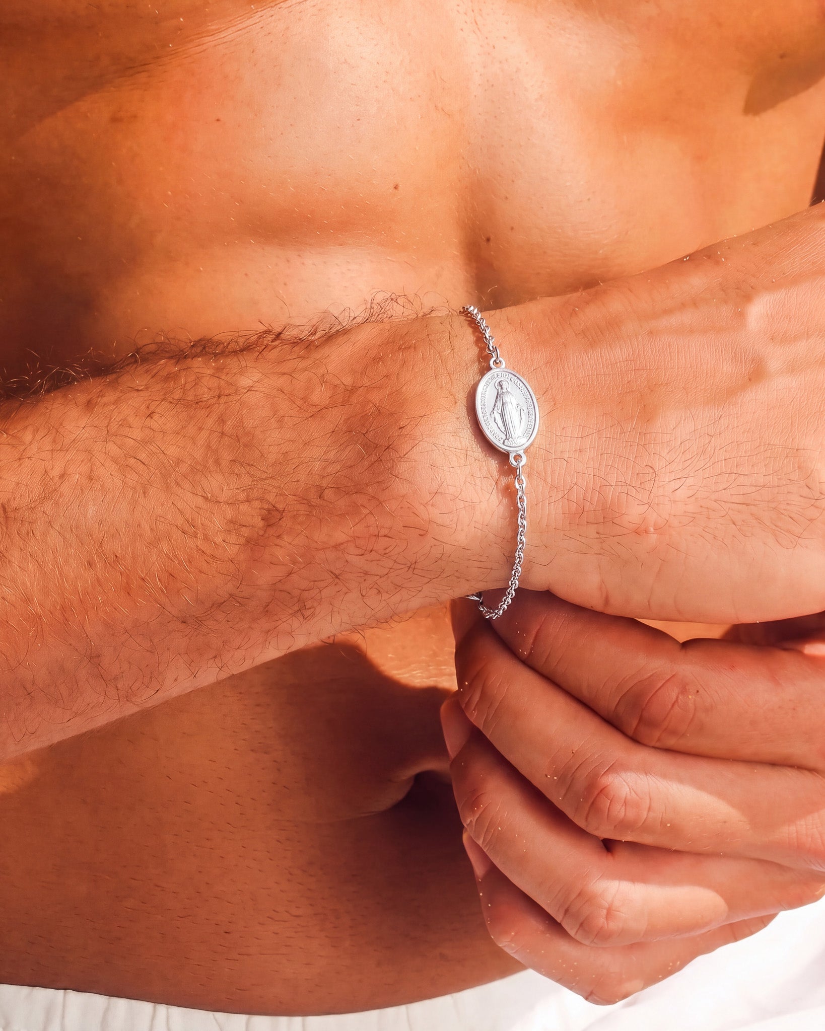 Silver Virgin Mary bracelet worn on the wrist